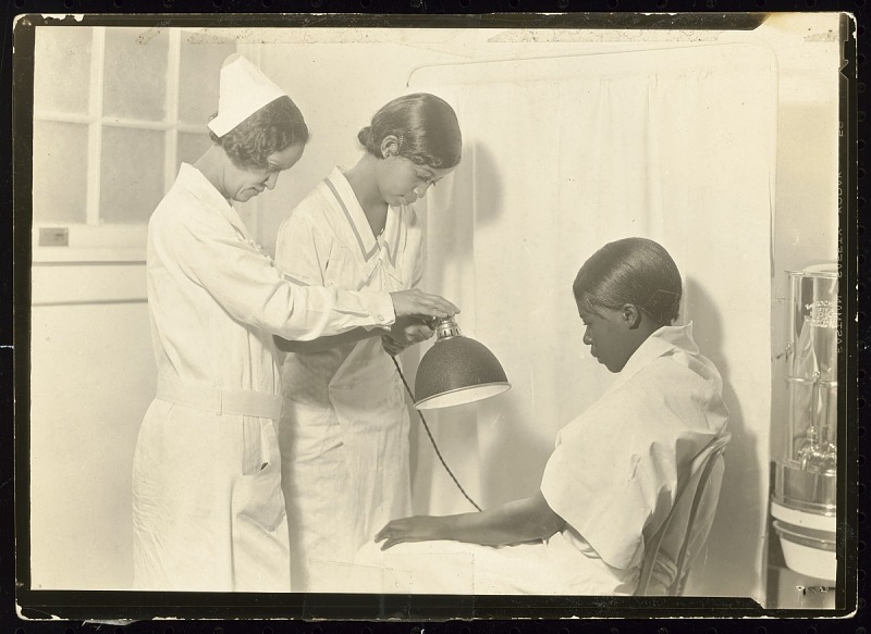A black and white photograph of three women learning to be nurses at the Manual Training and Industrial School for Colored Youth in Bordentown, New Jersey.